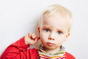 Young child pointing at their ear